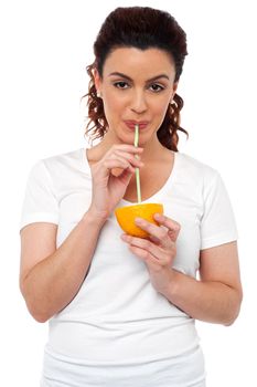 Active fit girl drinking fresh orange juice using a straw