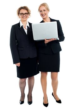 Full length portrait of senior businesswomen posing with laptop isolated against white background