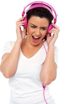 Brunette women enjoying rocking with loud music isolated over white