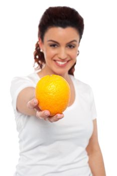 Smiling beautiful woman offering you an orange. Eat healthy, stay fit
