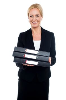 Cheerful female executive carrying business files, looking at camera
