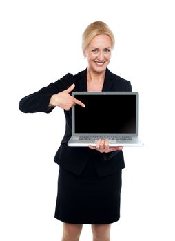 Smiling business lady indicating towards laptop screen isolated over white background