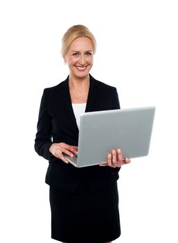 Corporate woman holding laptop and looking at camera
