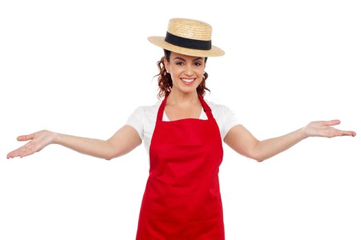 Pretty chef welcoming you with her arms stretched isolated over white background