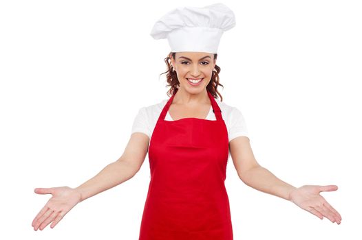 Smiling woman chef welcoming you to her workplace. Isolated over white background