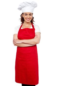 Profile shot of a young charming female chef wearing red apron and toque