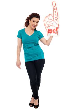 Woman cheering with large boo hurray foam hand. Full length portrait