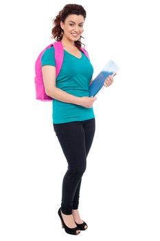 Attractive student with backpack and spiral notebook. Full length portrait