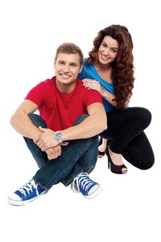 Attractive love couple sitting relaxed on floor. Indoor studio shot