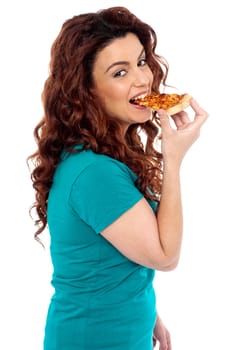 Side pose casual pretty girl enjoying pizza isolated over white