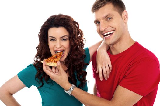 Boyfriend making her girl eat hot pizza piece. Both having fun