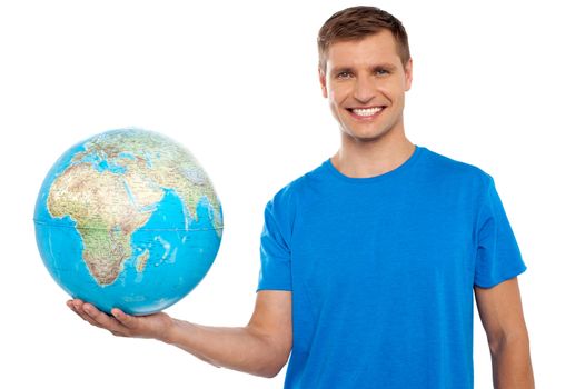 Attractive casual young man holding globe in his hand isolated over white