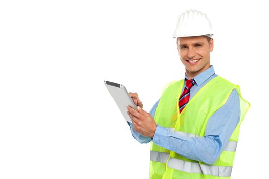 Construction engineer wearing safety hat and operating wireless device