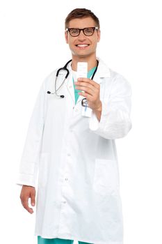 Smiling doctor showing tablets pack to camera isolated over white