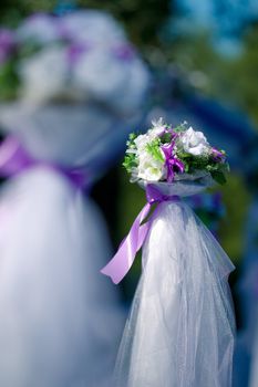 Wedding bunch of flowers decorated with purple ribbons and white organza