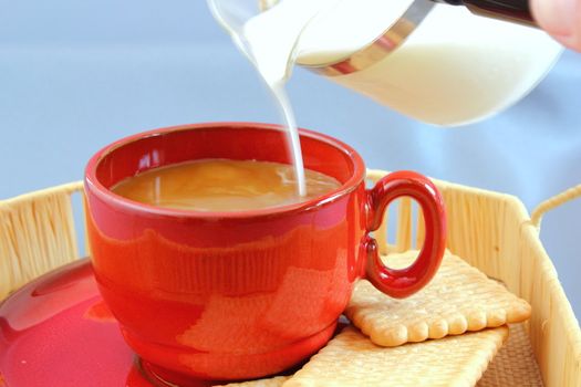 putting milk from a glass pot into the coffee