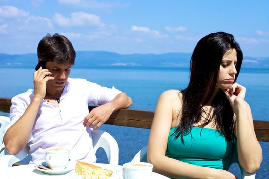 Handsome man on the phone girlfriend angry having breakfast on a lake