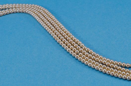 Pearl collar turn closeup over blue background.