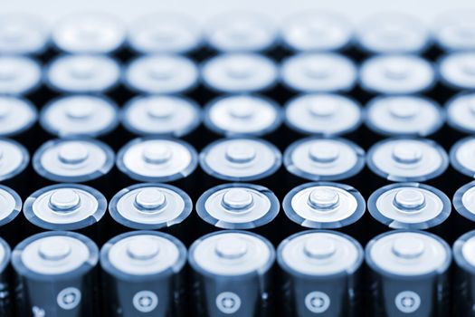 Tops of many AA batteries in closeup