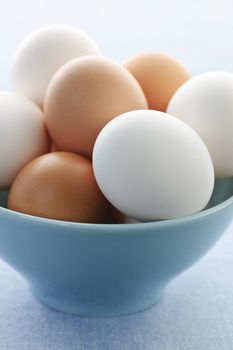 Closeup of white and brown eggs in bowl