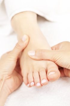 Female hands giving massage to soft bare foot