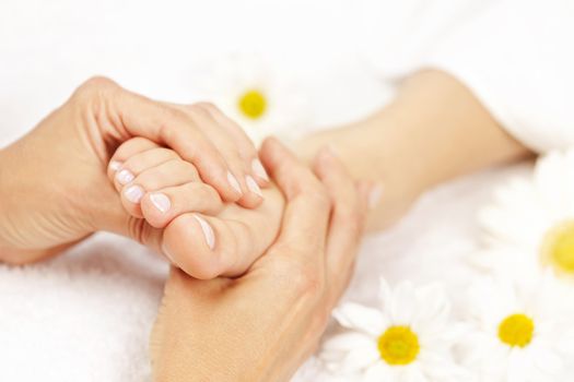 Female hands giving massage to soft bare foot