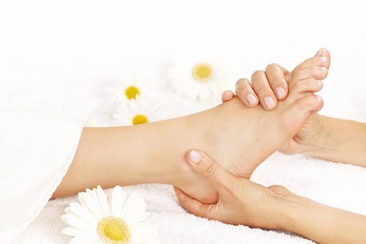 Female hands giving massage to soft bare foot