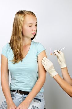 Teenage girl getting flu shot needle vaccination in arm