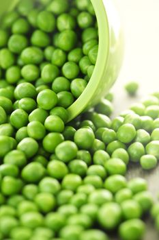 Closeup on spilling bowl of fresh green green peas