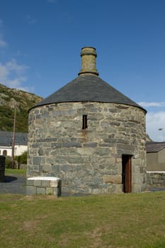 An historic stone built roundhouse with doorway, chimney and roof in the coast town of Barmouth, Gwynedd, Wales, UK.