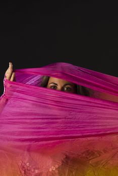 Mysterious eyes of a woman hiding behind a colorful headscarf