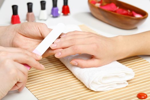 Young woman is getting manicure in a beauty salon