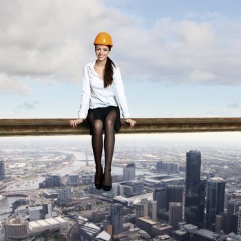 Business woman sitting high over a cityscape