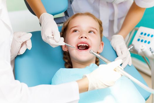 Little girl sitting in the dentists office