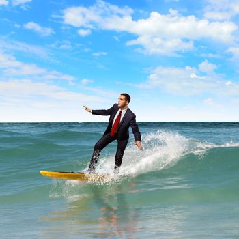 Image of young business person surfing on the waves of the ocean