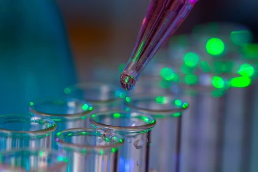 Pipette adding fluid to one of several test tubes