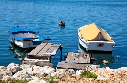 A small fishing two boats in blue sea (ocean or river) water
