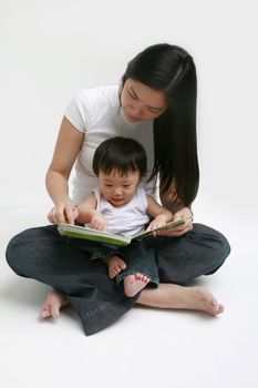 Young child and adult female looking at a book