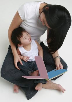 Young child and adult female looking at a book