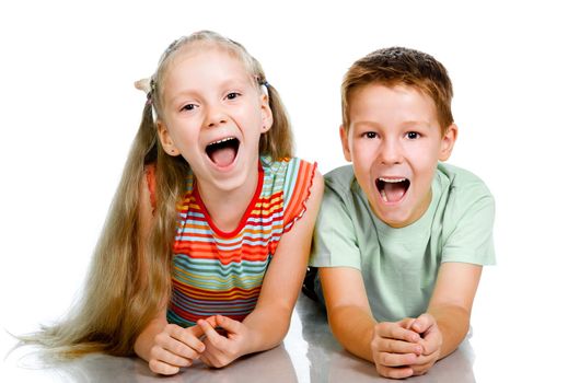 Smiling children lying on the white floor