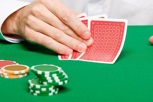 casino. Man's hand with cards and chips on a gambling table