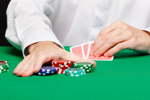 casino. Man's hand with cards and chips on a gambling table