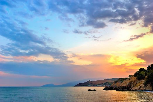 Sunset on the beach with a colorful sky and the rocks