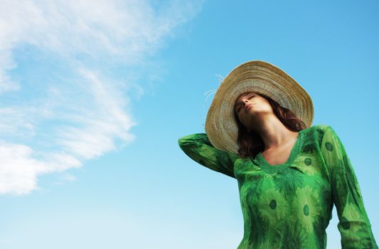 Beautiful young woman enjoying the sunny day against blue sky