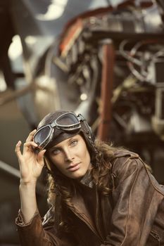 Portrait of young woman airplane pilot. Airplane on the background