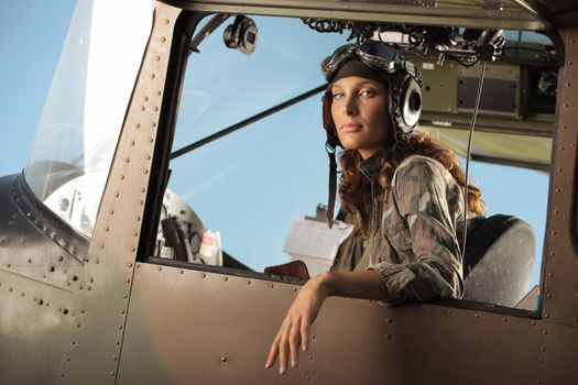 Portrait of young woman pilot in a military airplane