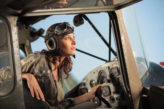 Portrait of young woman pilot in a military airplane