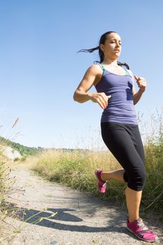 Low angle of young women running but coming to a stop.