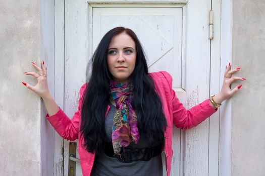 A beautiful girl standing in front of the closed white door.