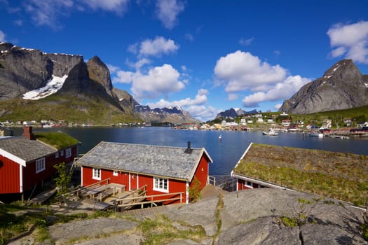 Red fishing rorbu huts by the fjord in town of Reine on Lofoten islands